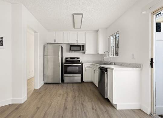 A modern kitchen with stainless steel appliances and white cabinets.