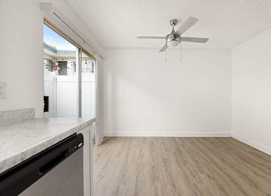 A room with a ceiling fan and a marble countertop.
