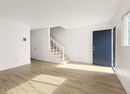 A room with a staircase leading to another room.