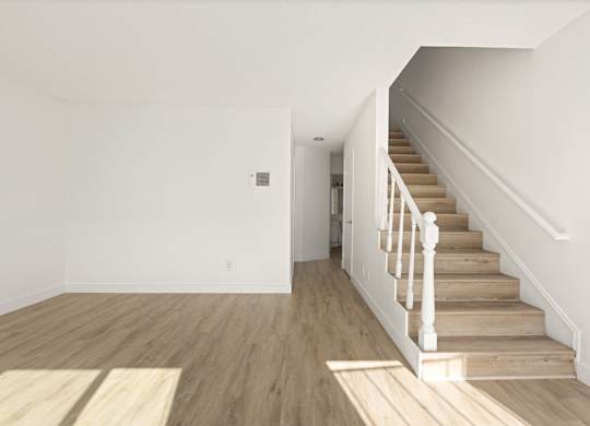 A room with a staircase leading to another room.