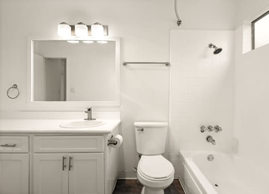 A white bathroom with a toilet, sink, and bathtub.