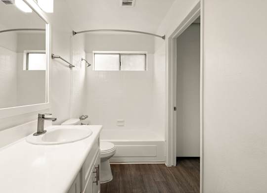 A white bathroom with a sink, toilet, and bathtub.