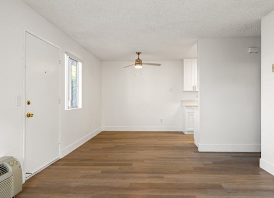A room with a ceiling fan and wooden flooring.