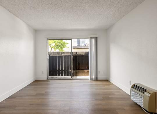 A room with a sliding door leading to a balcony.