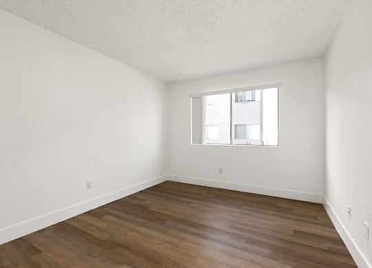 Empty room with wooden floor and a window.