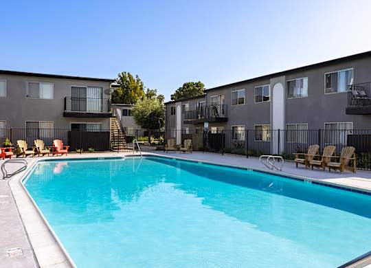 A swimming pool in front of apartment buildings.