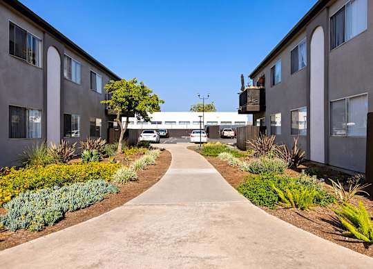 A concrete pathway leads between two rows of buildings.