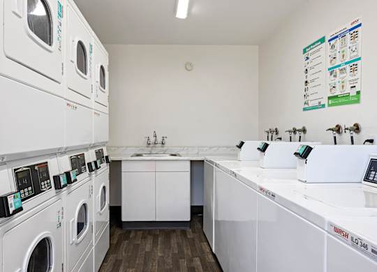 A laundromat with a row of washers and dryers.