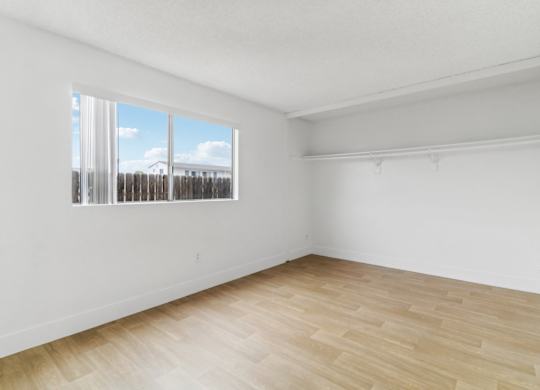 Empty room with wooden floor and a window.