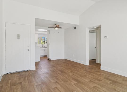A room with a white door and a wooden floor.