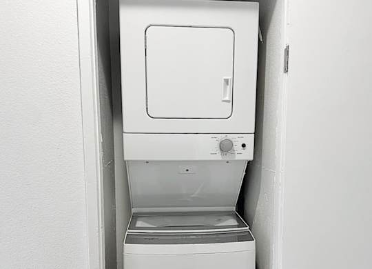 A white dishwasher is installed in a white wall.