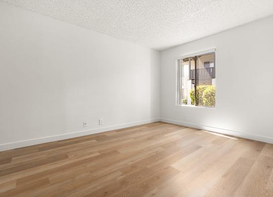 A room with wooden flooring and a window.