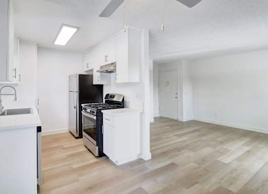 A kitchen with a black oven and white cabinets.
