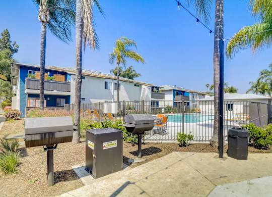 A sunny day at a residential area with palm trees and a pool.