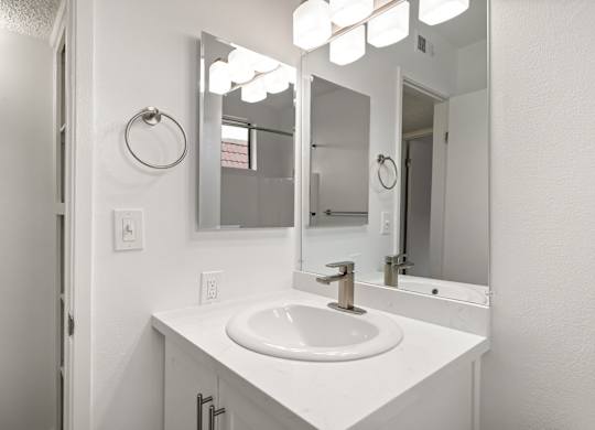 A white bathroom sink with a mirror above it.