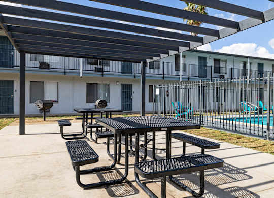 A black table and benches are set up under a black awning.