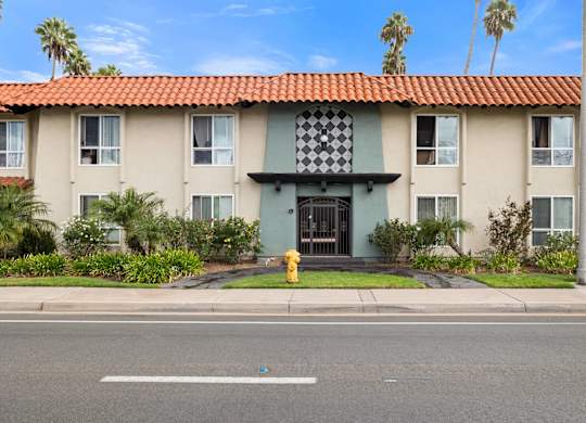 A building with a red tile roof and a black and white checkered awning.