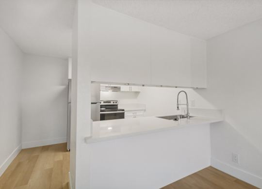 A kitchen with white cabinets and a sink.