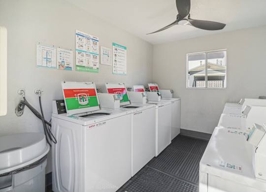 A row of washing machines are lined up in a laundromat.