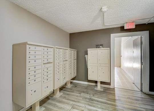 A room with a row of filing cabinets and a red exit sign above them.