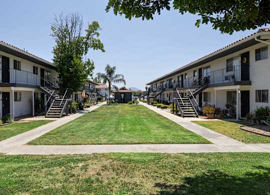 A row of apartment buildings with green lawns in front.