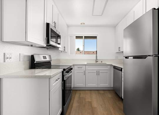 A modern kitchen with stainless steel appliances and white cabinets.