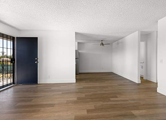 A room with a dark blue door and wooden flooring.