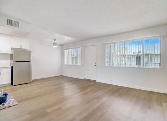 A room with a refrigerator and a ceiling fan.