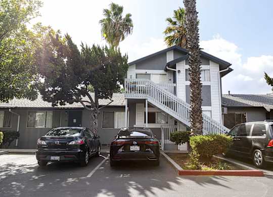 A black car is parked in front of a house.