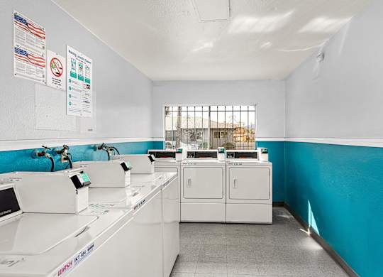 A clean, well-organized laundry room with washers and dryers.
