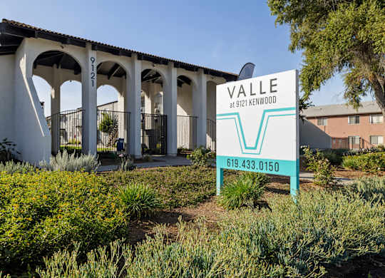 A sign for Valle at 9121 Kenwood stands in front of a building.