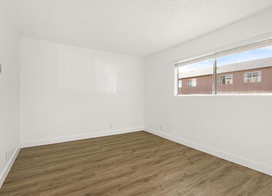 Empty room with wooden floor and white walls.