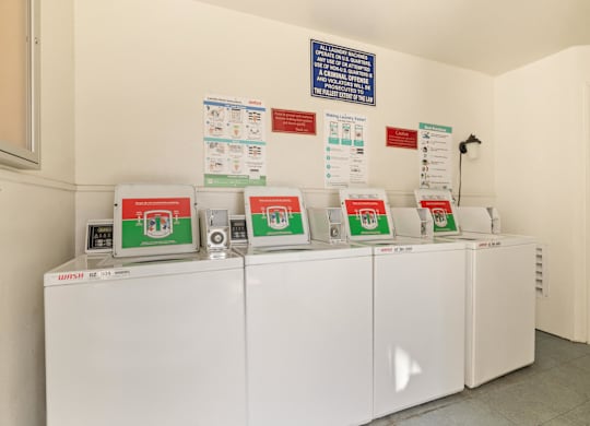 A row of washing machines are lined up in a laundromat.