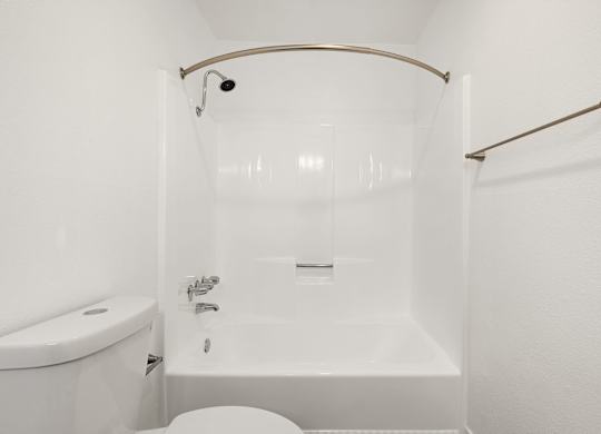 A white bathroom with a tub, toilet and sink.