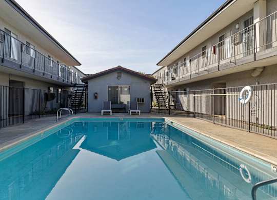 A swimming pool in a residential area surrounded by apartment buildings.