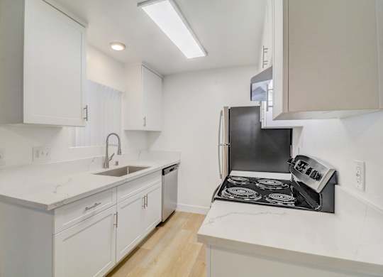 A kitchen with white cabinets and a black stove top oven.
