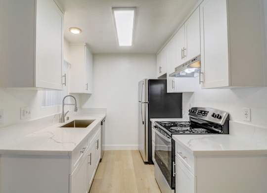 A kitchen with white cabinets and appliances.