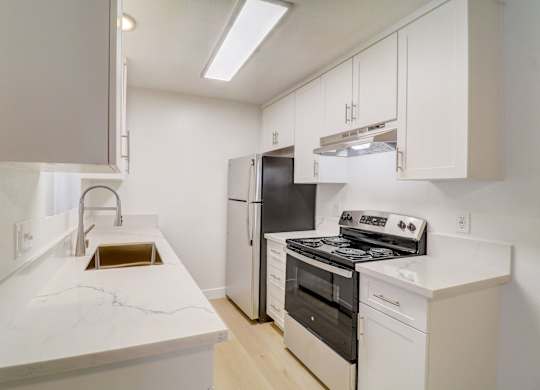 A kitchen with white appliances and cabinets.