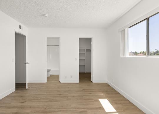 A large empty room with a toilet in the middle.