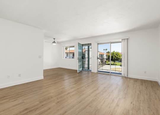 A room with a sliding glass door leading to a balcony.
