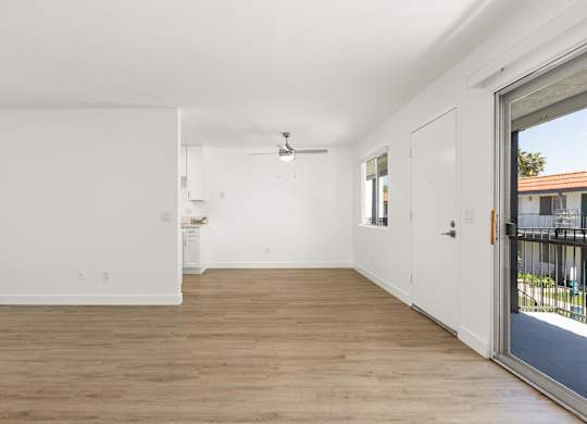 A room with a sliding glass door leading to a balcony.