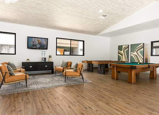 A living room with a black couch, a wooden coffee table, and a rug.