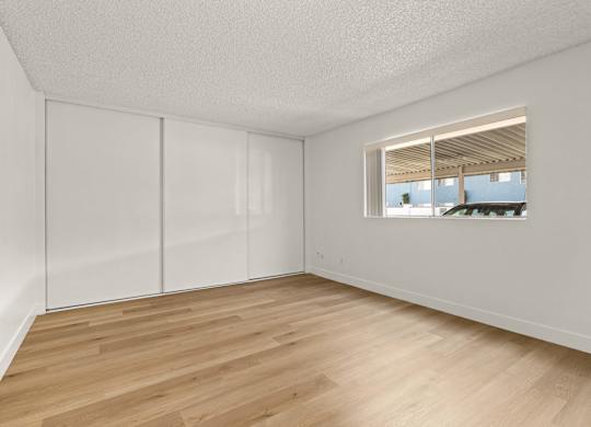 Empty room with white walls and wooden floor.