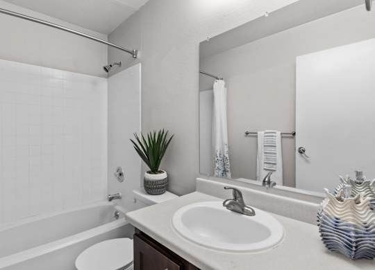 A bathroom with a white sink and a white toilet.