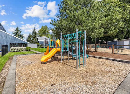 A playground with a yellow slide and a blue structure.