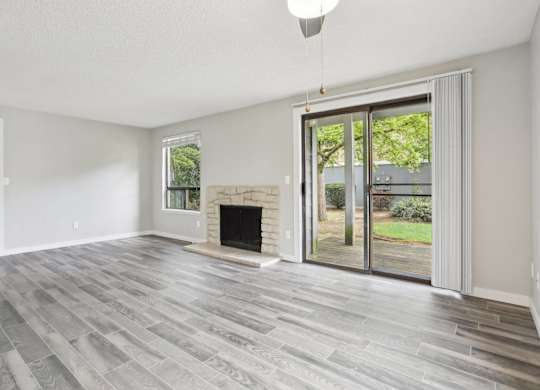 A room with a fireplace and sliding glass doors.