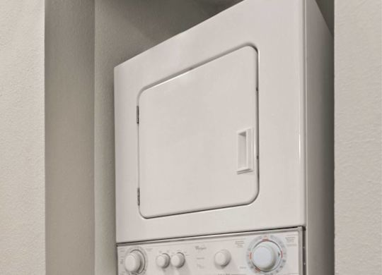 A white oven and dishwasher are mounted on a wall.
