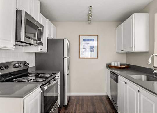 A kitchen with white cabinets and a black stove top oven.