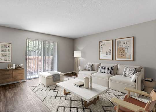 A living room with a white couch, a wooden chair, a coffee table, and pictures on the wall.