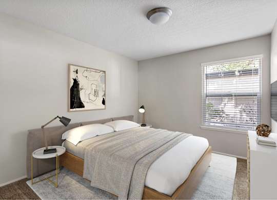 A bedroom with a bed, nightstand, and a painting on the wall.